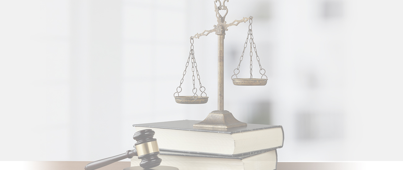 Scales of justice and books and gavel on wooden table